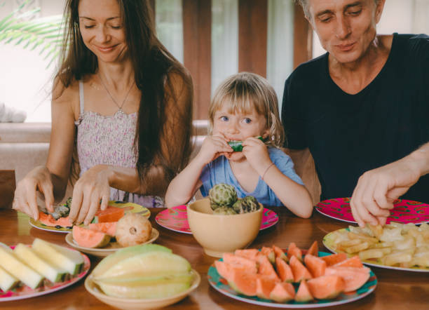 Family eats  tropical fruits on patio