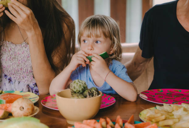 Family eats  tropical fruits on patio