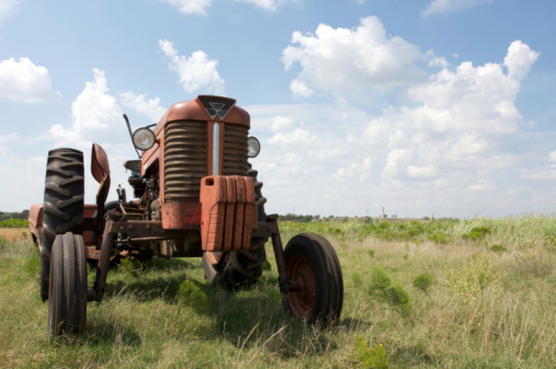 A vintage tractor is left in a field after a breakdown.