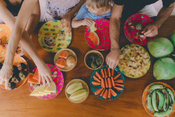 Family eats  tropical fruits on patio