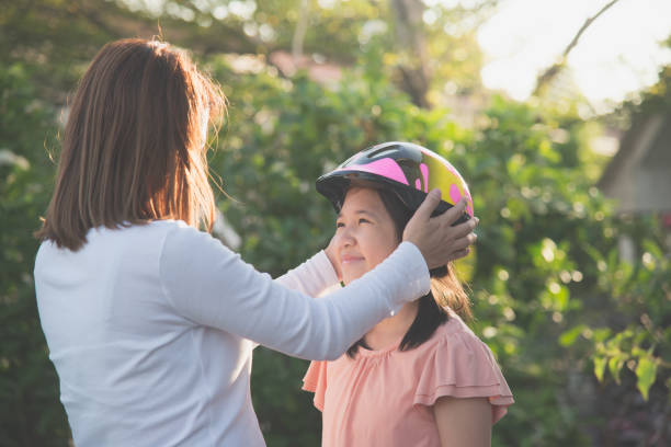 istock mother wears a bicycle helmet to her daughter 929606200