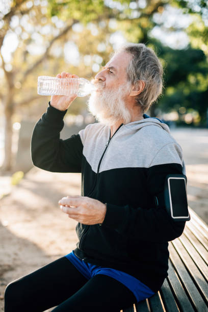 istock Senior male runner rests and drinks water 929606618