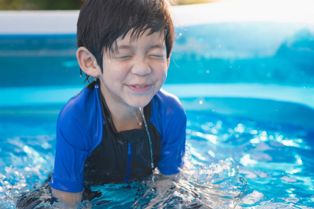 istock Boy swimming and playing in a pool 929606876