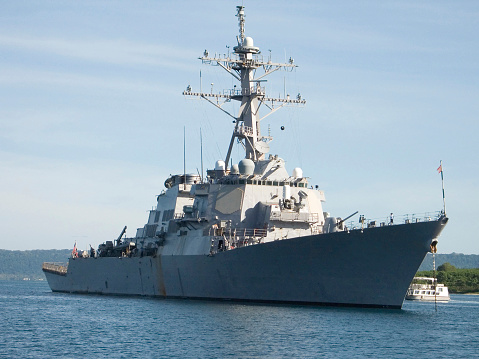 Navy frigate enters a harbour after offshore training exercises.