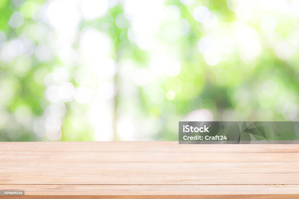 Tavolo in legno vuoto con bokeh verde natura Defocus, sfondo naturalistico astratto. - Foto stock royalty-free di Tavolo