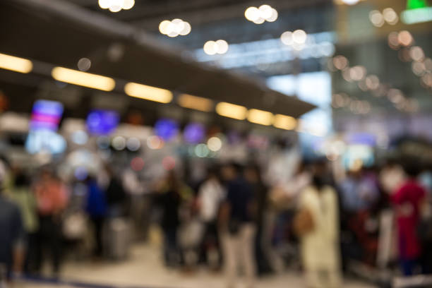 istock Blurred image of airport check-in counters with passengers and crowded. 929609726