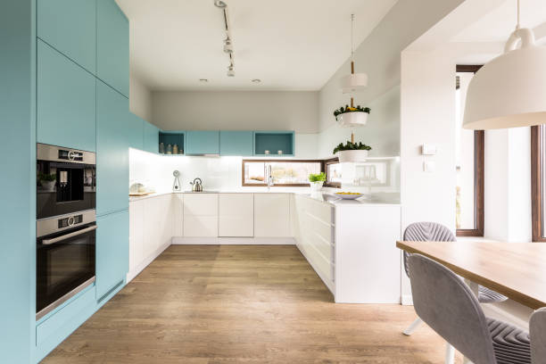 Blue and white kitchen interior Blue and white cabinets in modern kitchen interior with wooden floor turquoise coloured stock pictures, royalty-free photos & images