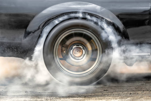 Drag racing car burns rubber off its tires in preparation for the race Drag racing car burns rubber off its tires in preparation for the race drag racing stock pictures, royalty-free photos & images