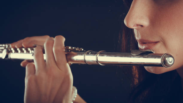 istock Woman playing transverse flute on black. 929653250