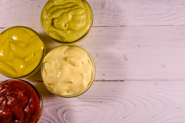 istock Different sauces in glass bowls on wooden table. Top view 929667704