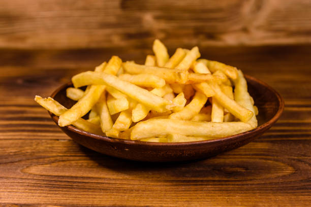 istock Ceramic plate with french fries on wooden table 929667748