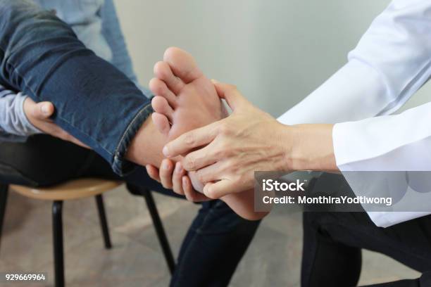 Closeup Of Man Feeling Pain In Her Foot And Doctor The Traumatologist Examines Or Treatment On White Background Healthy Concept Stock Photo - Download Image Now
