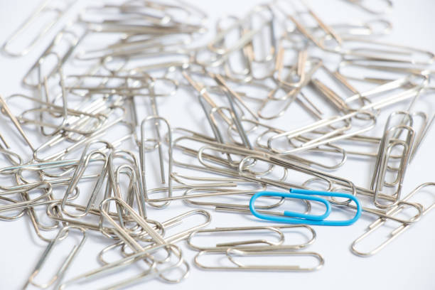 istock Blue color paper clip with another silver item on white background (Concept differentiation, unique, limited or special one) 929671654