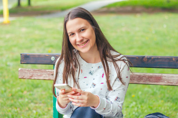 istock Teenage girl using mobile phone in park. 929676798