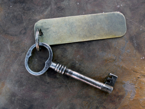 Vintage key with keytag on old table as background, write your own key tag!