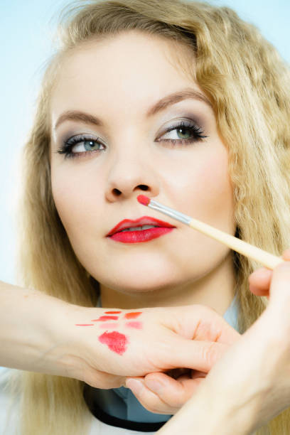 istock Applying lipstick on fashion model lips 929692916