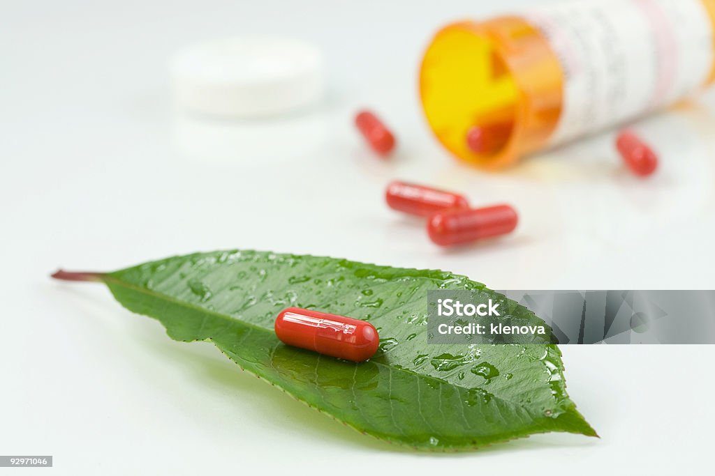 Pílula vermelho sobre uma folha verde - Royalty-free Analgésico Foto de stock