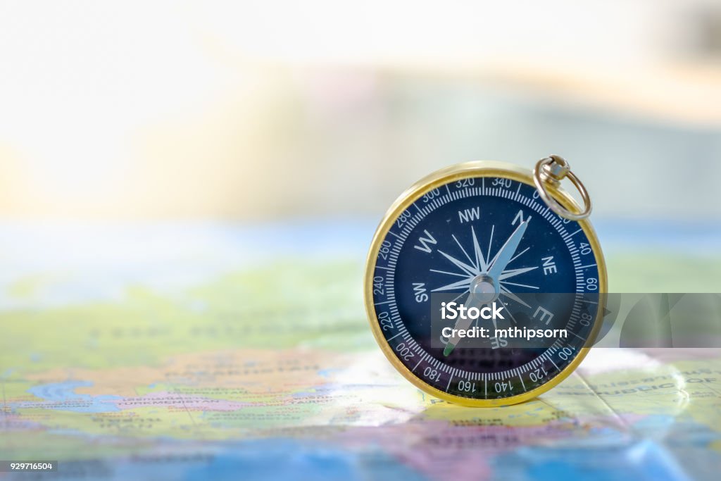 Travel Concept. Close up of compass on world map. Navigational Compass Stock Photo