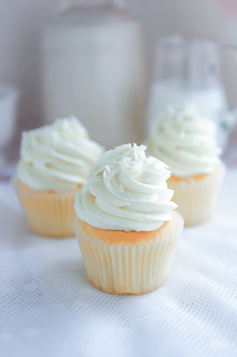 Vanilla cupcakes frosting with butter cream serve with milk.