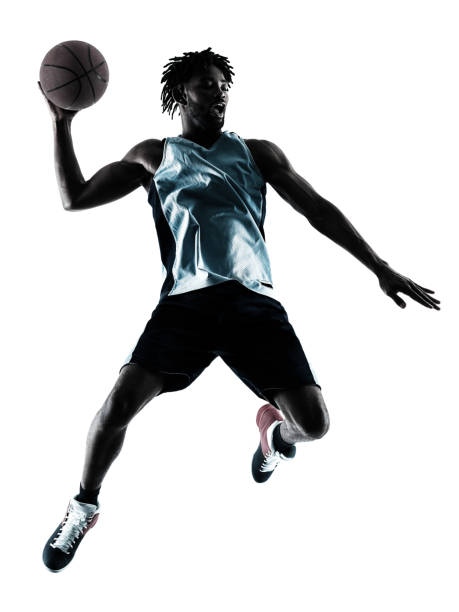 basketball player man isolated silhouette shadow one afro-american african basketball player man isolated in silhouette shadow on white background silhouette of basketball player slam dunk stock pictures, royalty-free photos & images