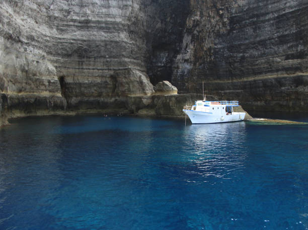 Lampedusa, Itay - September 30, 2009: touristic boat near the sacramento cliff
