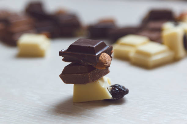 istock Pieces of black, milk and white chocolate on the table. 929735816