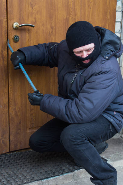 istock criminal breaks open the door with a crowbar 929739502