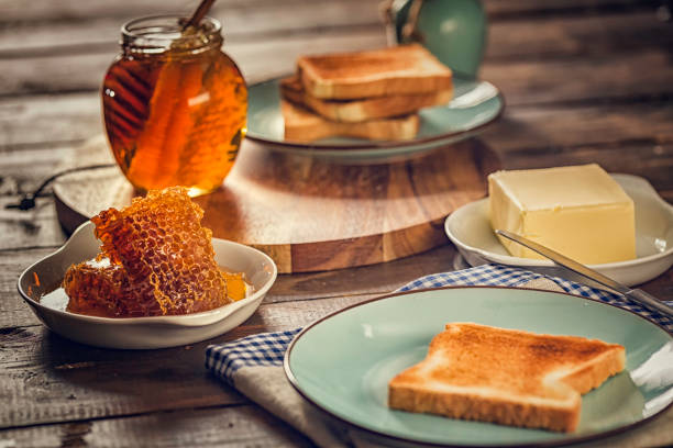 Preparing toast with butter and delicious honey for breakfast