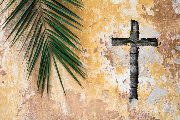 パーム枝とキリスト教の十字または古いヴィンテージの伝統的な壁の十字架 ストックフォト
