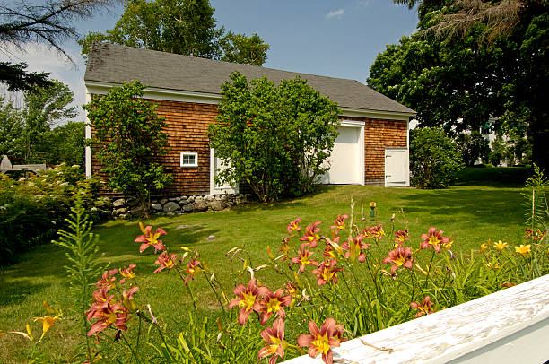 Barn with tiger lilies in the foreground stock photo