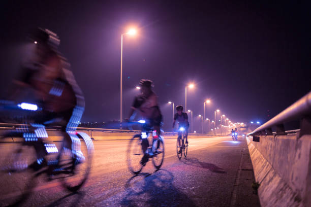Blurry of Cyclists ride through lighted city stock photo