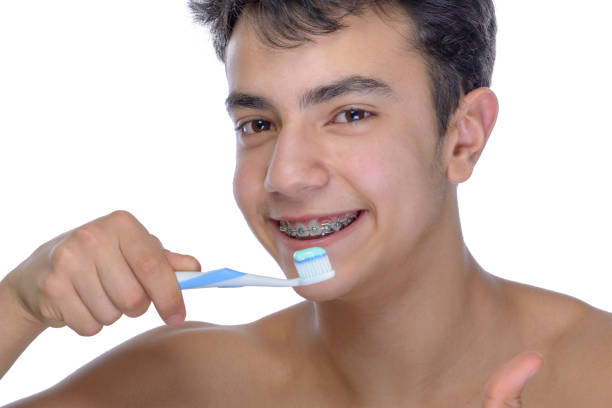 istock Teen boy wearing braces on white background 929760694