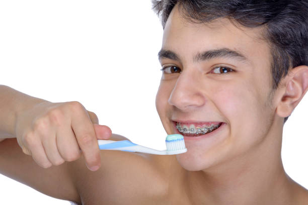 istock Teen boy wearing braces on white background 929760696