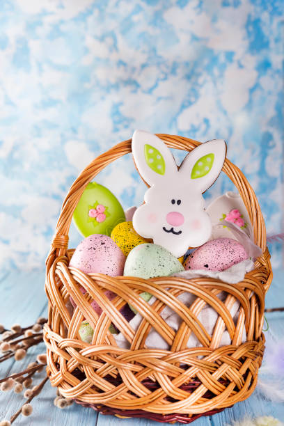 istock Easter cookies, bunnies and eggs in a basket on light blue background 929760776