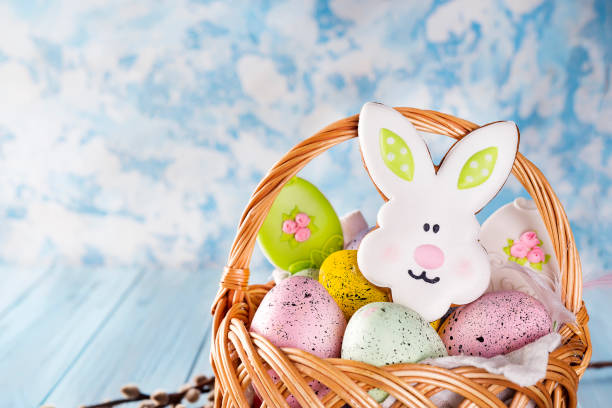 istock Easter cookies, bunnies and eggs in a basket on light blue background 929761370