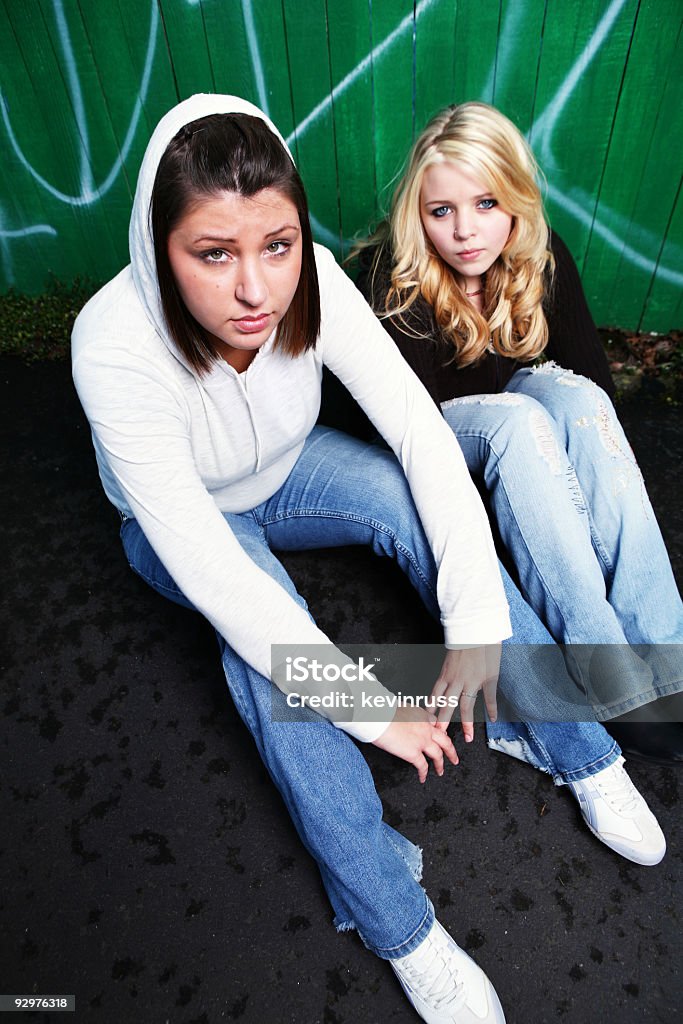 You Young Female Models Sitting. young women and a green fence Adult Stock Photo