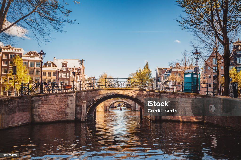 Amsterdam cityscape with canal and bridges in Netherlands Center of Amsterdam city landscape scene with typical houses, bridges and water canal in sunny summer day Amsterdam Stock Photo