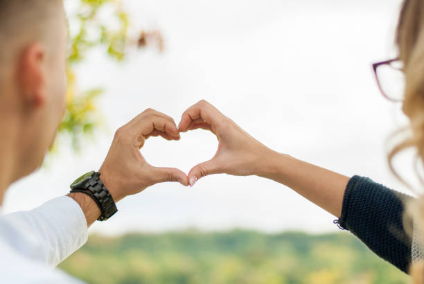 istock Men and women in love, make shape hearts by hand 929764436