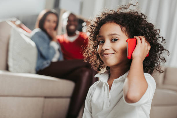 istock Pleased kid using cellphone in living room 929764610
