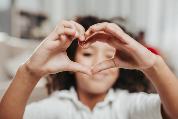 istock Enjoyed child peeping through heart shaped fingers 929764876