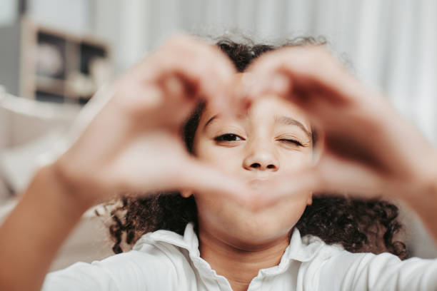 istock Serene child holding hands in shape of heart 929764882