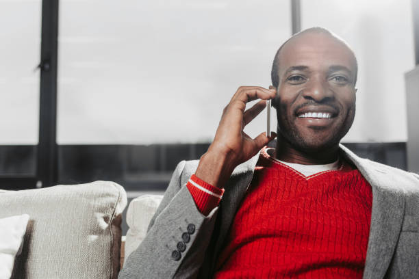 istock Glad african man chatting by mobile phone 929767610