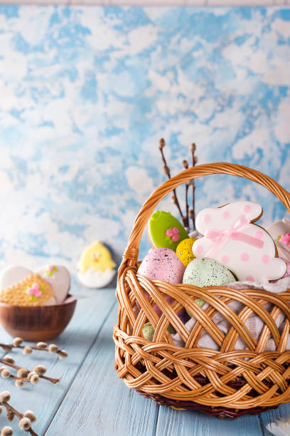 istock Easter cookies, bunnies and Multicolored Easter eggs in a basket on light blue background 929768378