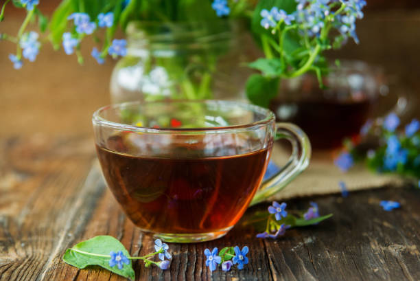 istock Cup of tea with lilac flowers on marble background 929775198