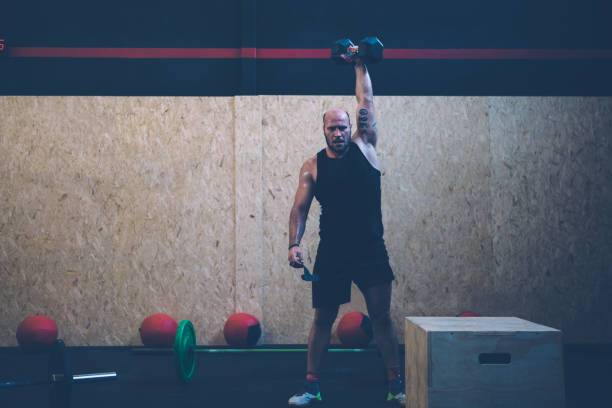 istock Male athlete doing dumbbell snatch 929780142