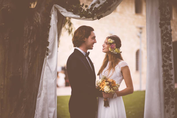 istock Bride and groom standing together at beautiful garden wedding ceremony 929780184