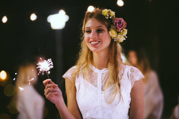 Happy elegant bride celebrating with sparklers at wedding party