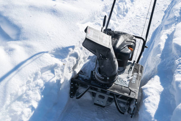Snowblower at work on a winter day. Snowplow removing snow after blizzard. Clearing the ice. Snow removal machine. Clear driveway with a snowblower. Snow blower. Snow plower. máquina removedora de nieve en el trabajo en un día de invierno. barredora de nieve quitando la nieve después de blizzard. claro el hielo. máquina del retiro de nieve. entrada clara con una máquina removedora de nieve. soplador de nieve. plower de la nieve.