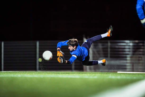 gardien de but attraper le ballon dans les airs - goalie soccer soccer player teenage boys photos et images de collection