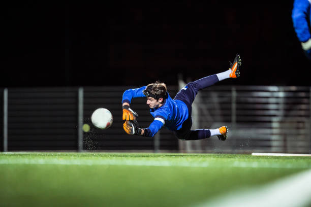 вратарь ловить мяч в воздухе - goalie soccer soccer player teenage boys стоковые фото и изображения